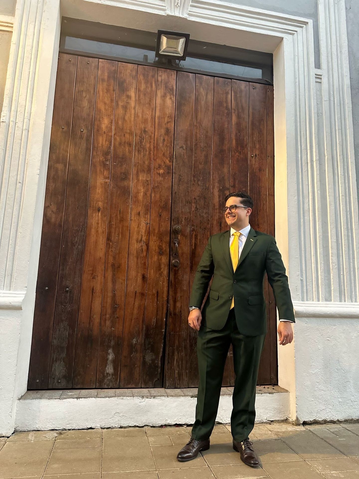 Kunde i skreddersydd mørkegrønn dress med gult slips fra Rashmi Custom Tailors